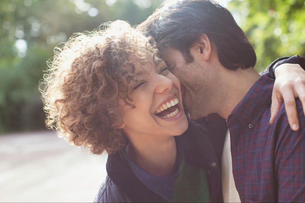 A man kissing a woman’s neck.