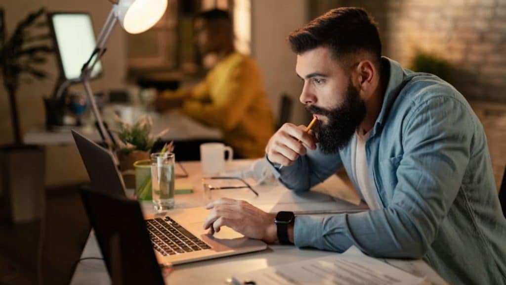 Man marking something on an online calendar with a thoughtful expression