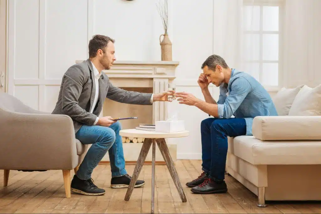 A man getting a water from other man.