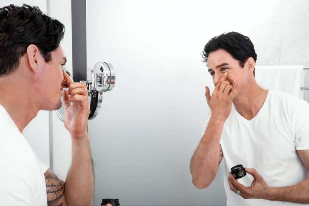 A man moisturizing his face.