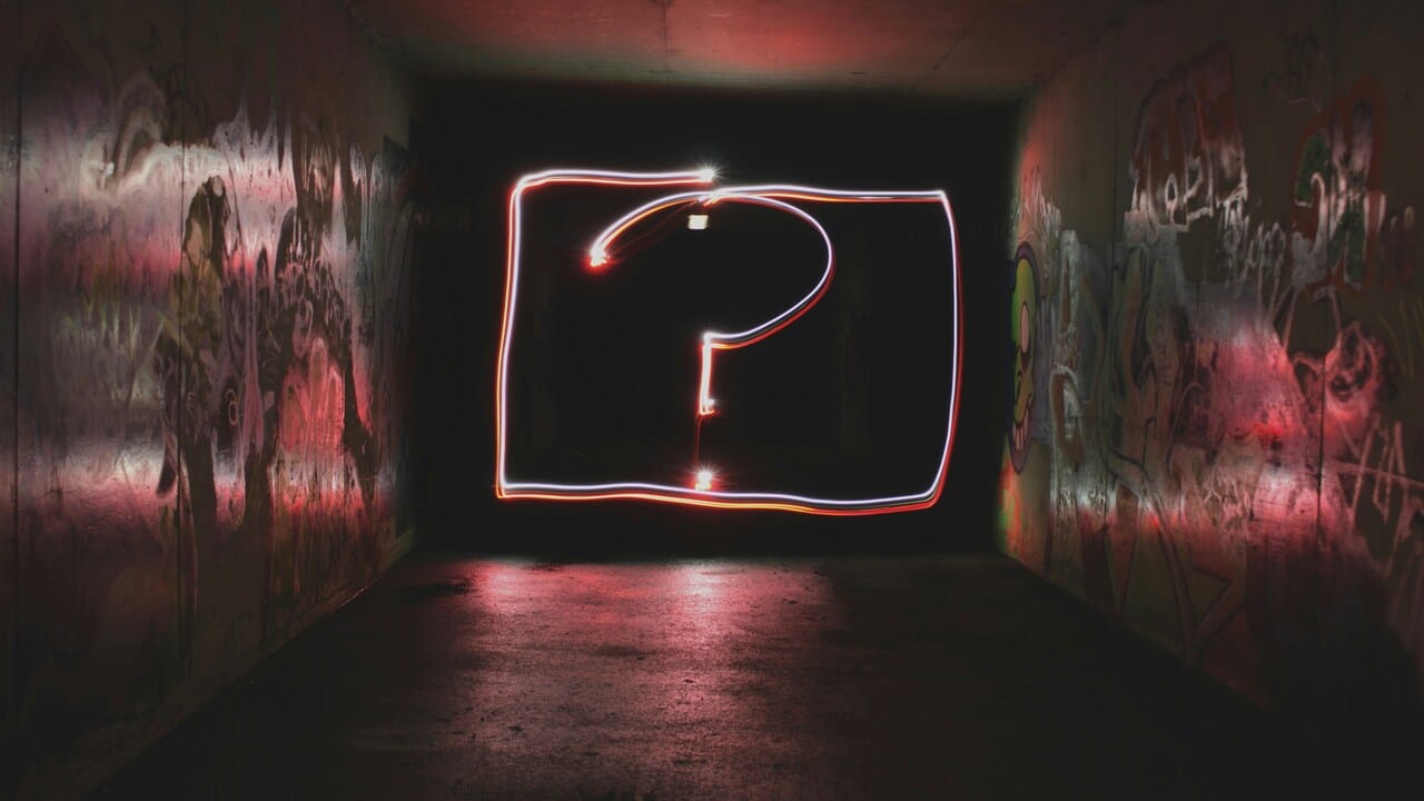 A neon light shaped as a question mark.