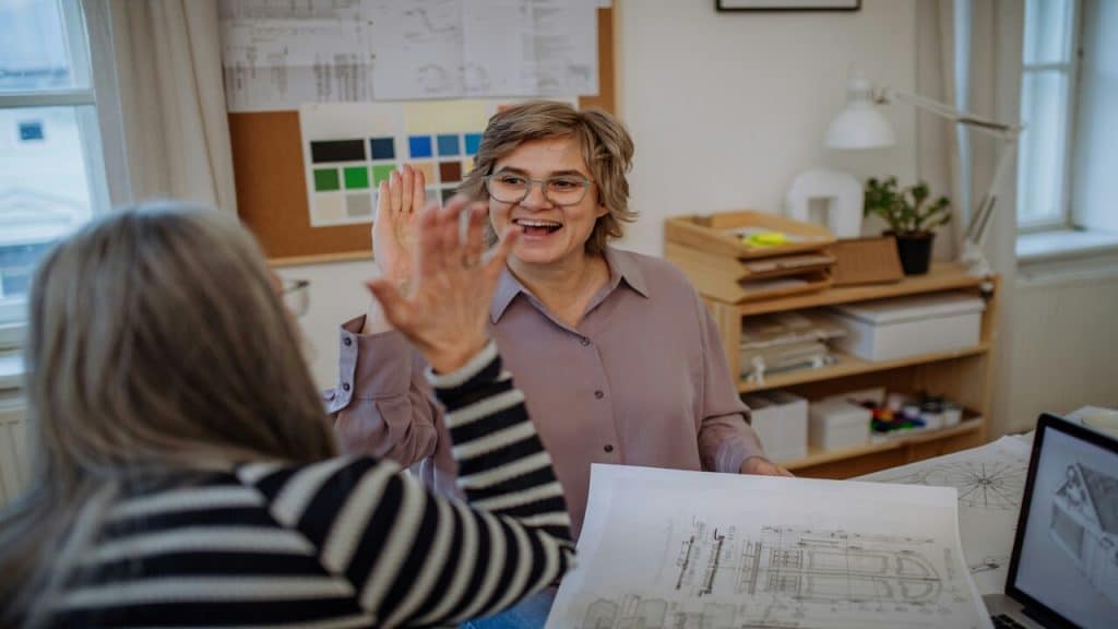 Two colleagues high-fiving at work