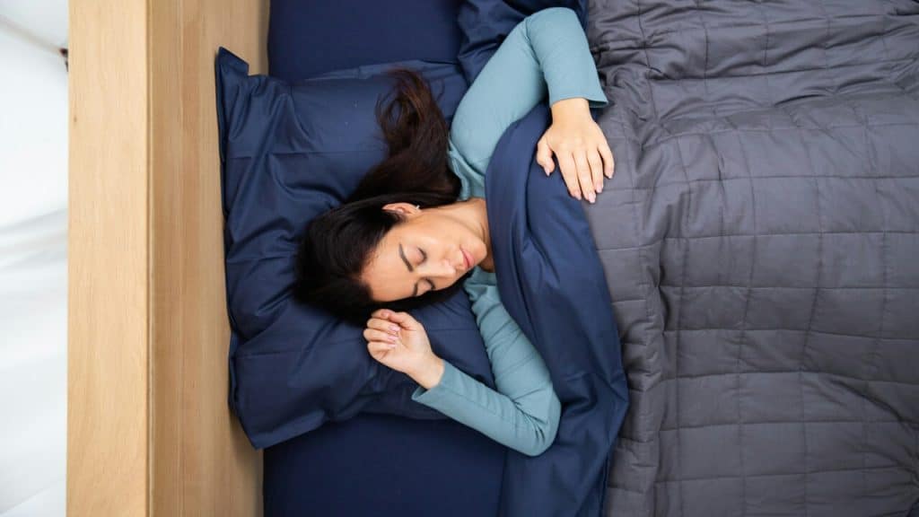 A woman using a weighted blanket