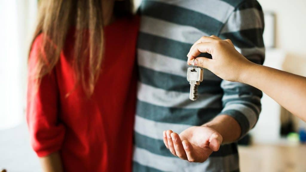 A couple receiving keys handed to them.