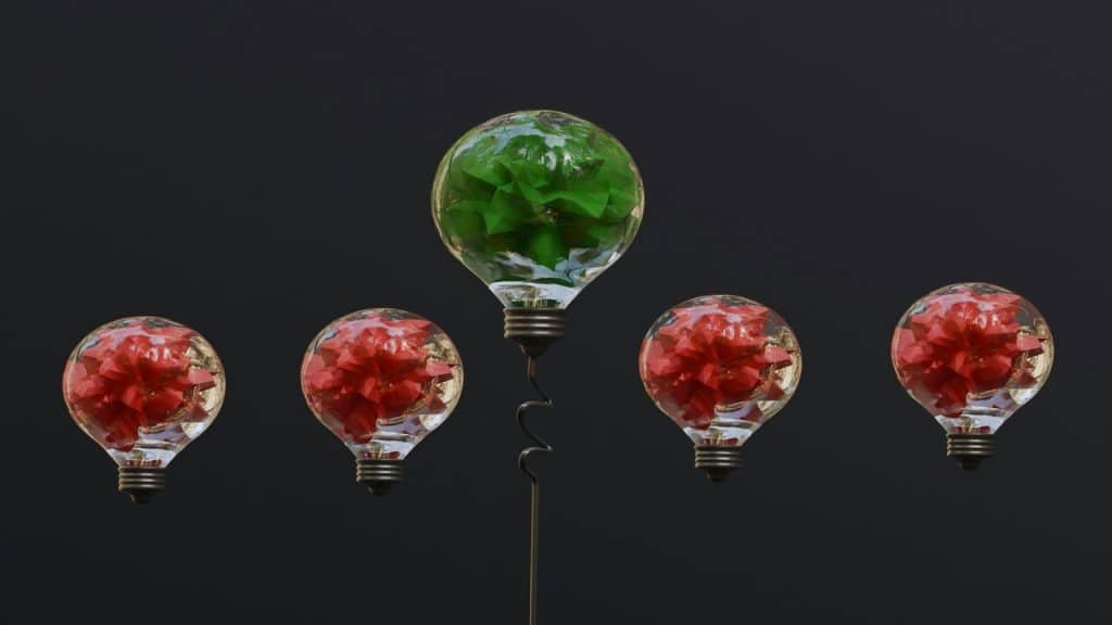 A green light bulb over red light bulbs