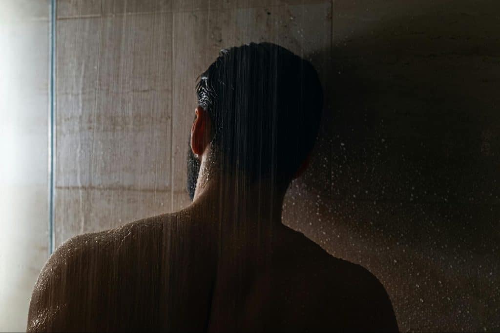 A man just standing below the shower