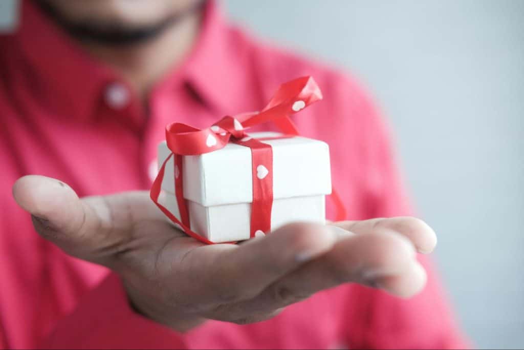 A man holding a box with a ribbon