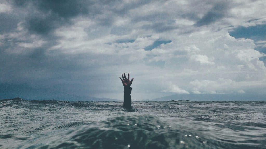 A hand reaching out above the water