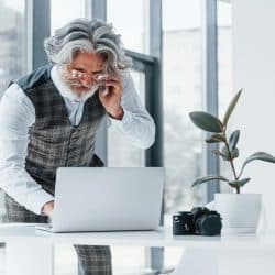 A handsome older man working in an office.