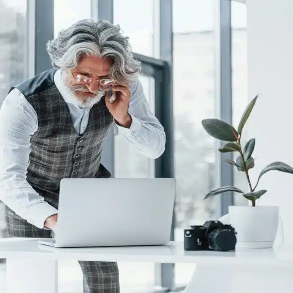 A handsome older man working in an office.