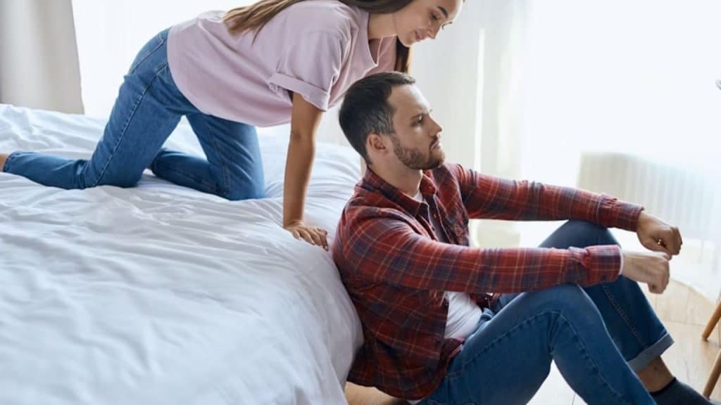 Man expressing emotion while being comforted by his partner