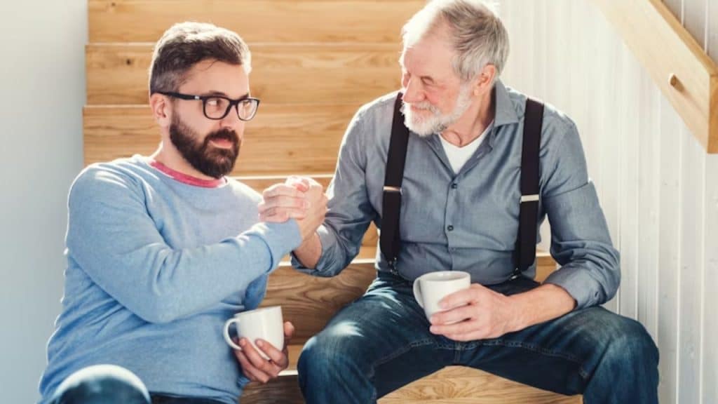 Older man mentoring a younger man over coffee