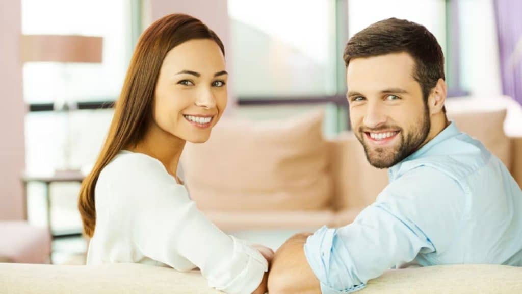 A man and woman sitting with a respectful physical distance, smiling warmly