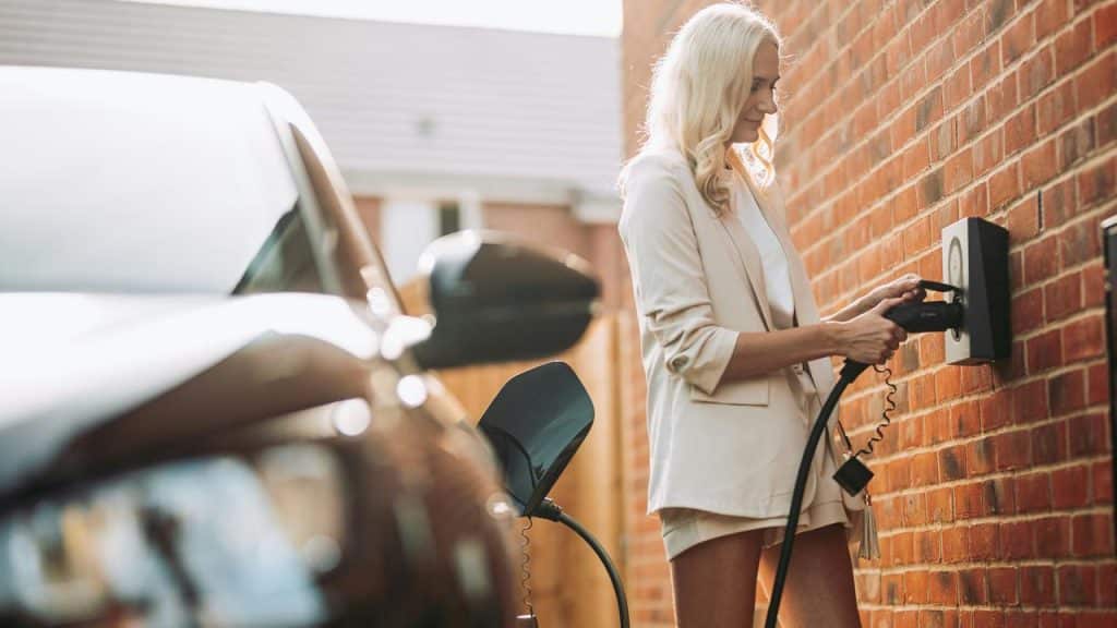 A woman charging an electric car.