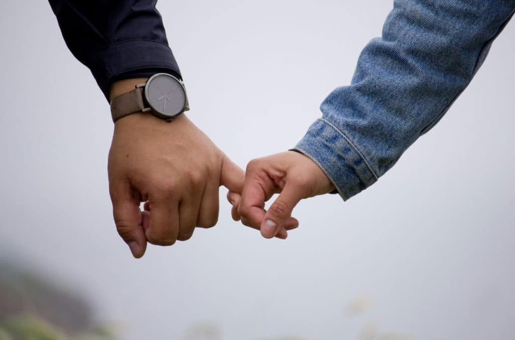 A man doing pinky promise to another person.