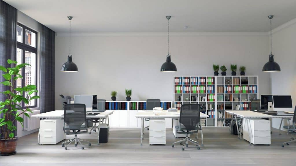 An open-plan office space with desks, chairs, and computer monitors.