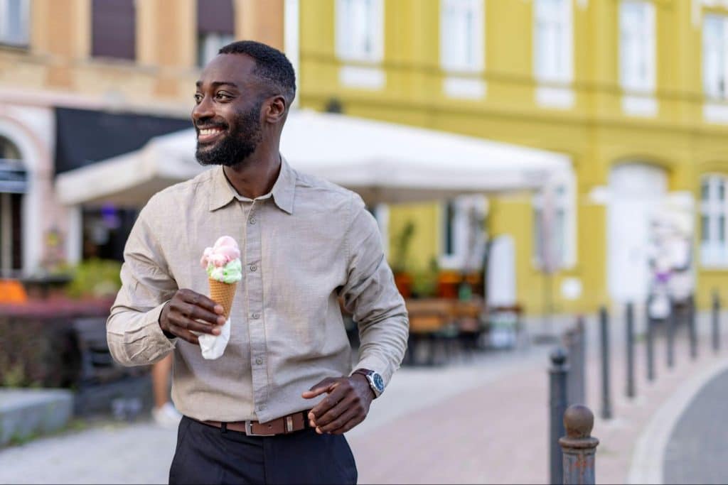A man walking outside with an icecream.