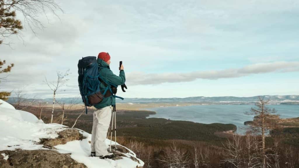 A man taking a solo weekend hike while on a call with his partner