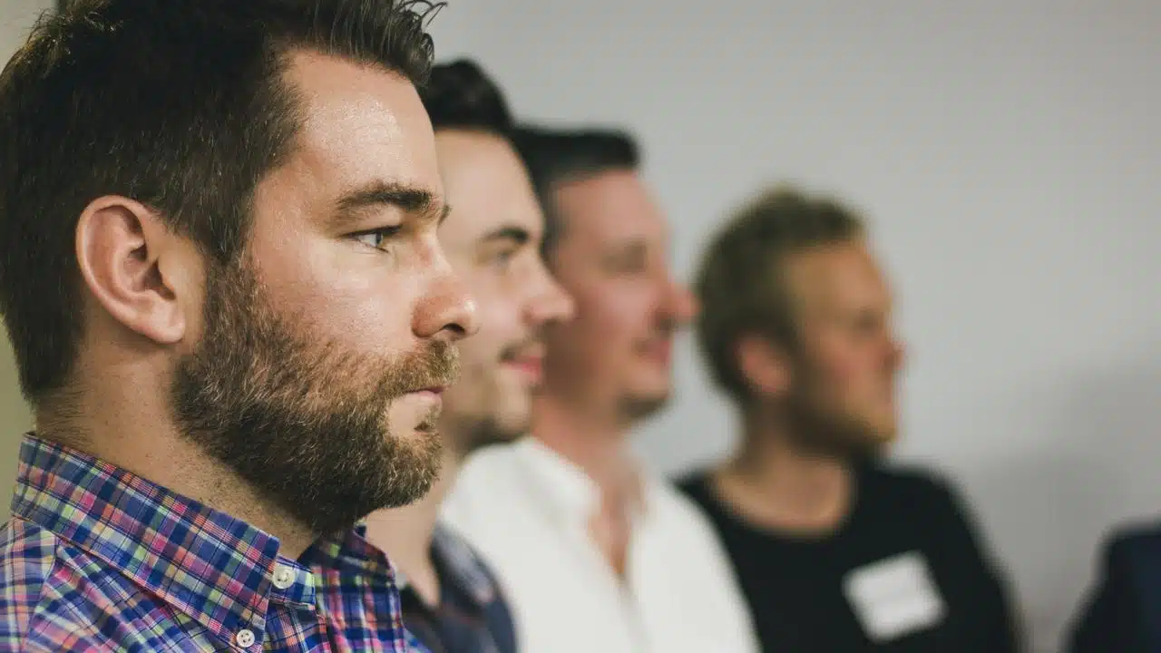 A row of men listening attentively.