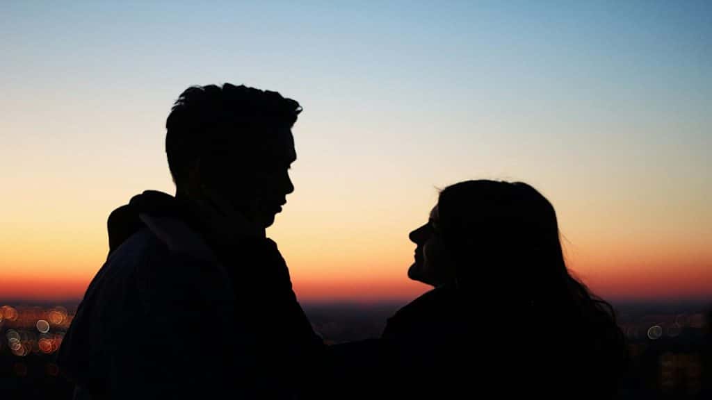 A couple looking at each other at sunset