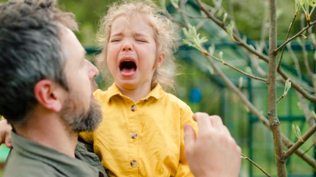 Man talking calmly with his child during a tense moment.
