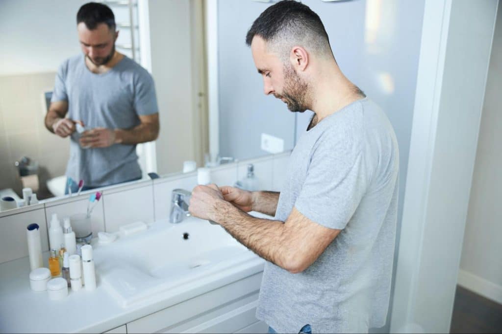 A man checking a product to use for grooming.