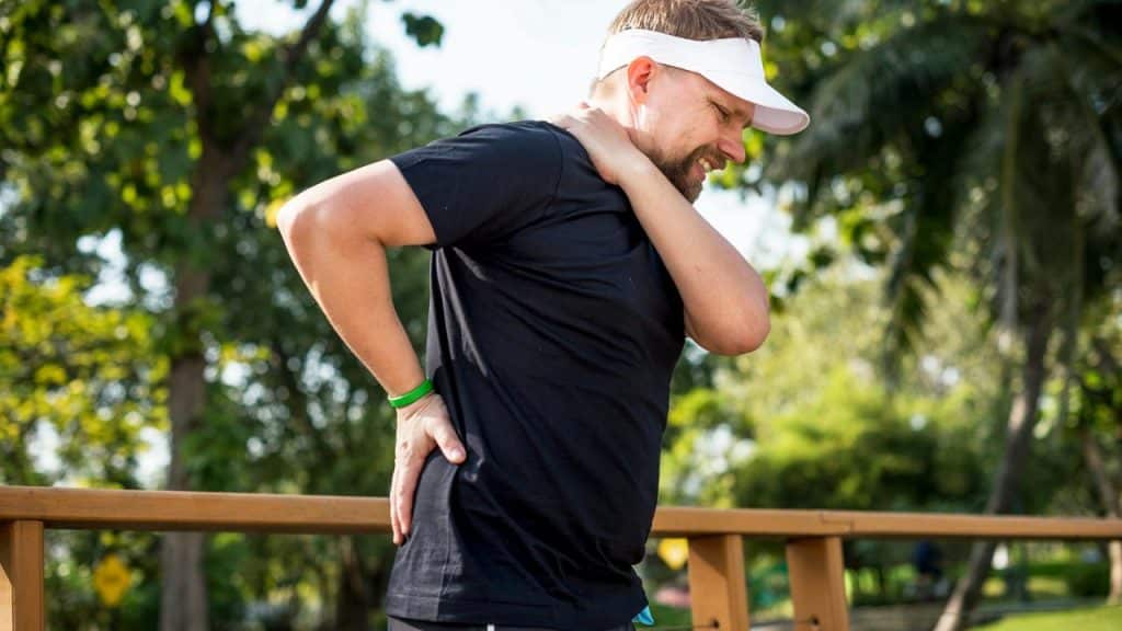 A man clutching his neck and lower back.