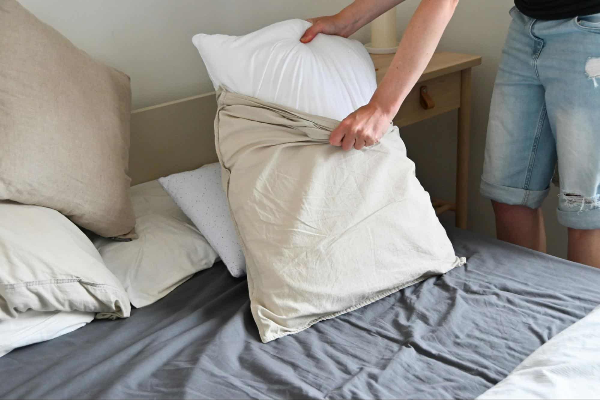 A man changing pillowcases.