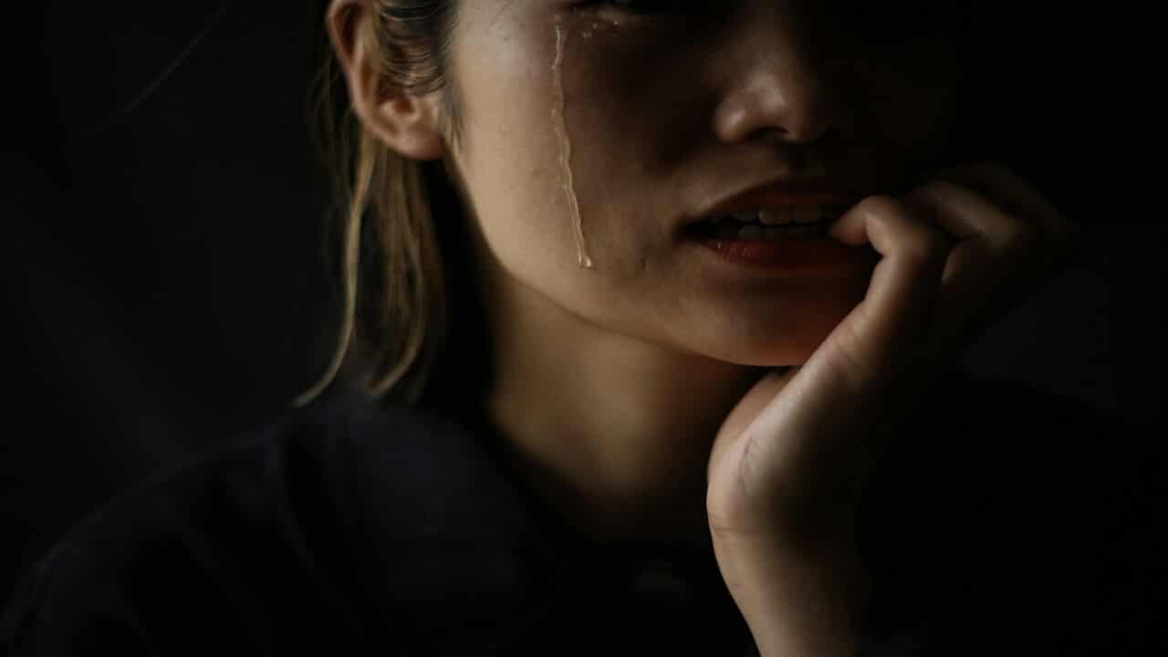 A woman crying in the dark.
