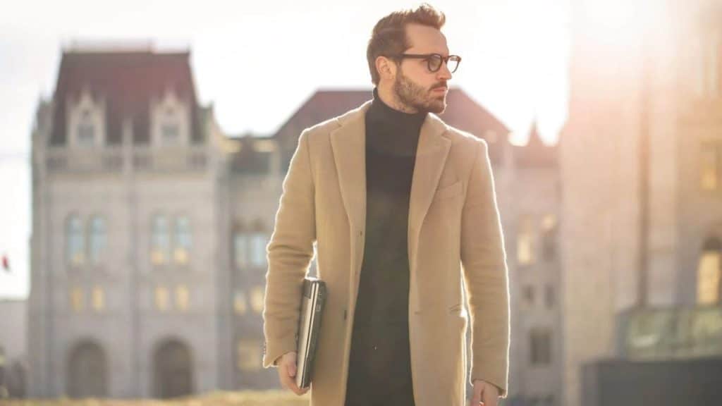 A confident, casually dressed man walking with purpose through a modern city