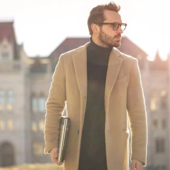 A confident, casually dressed man walking with purpose through a modern city