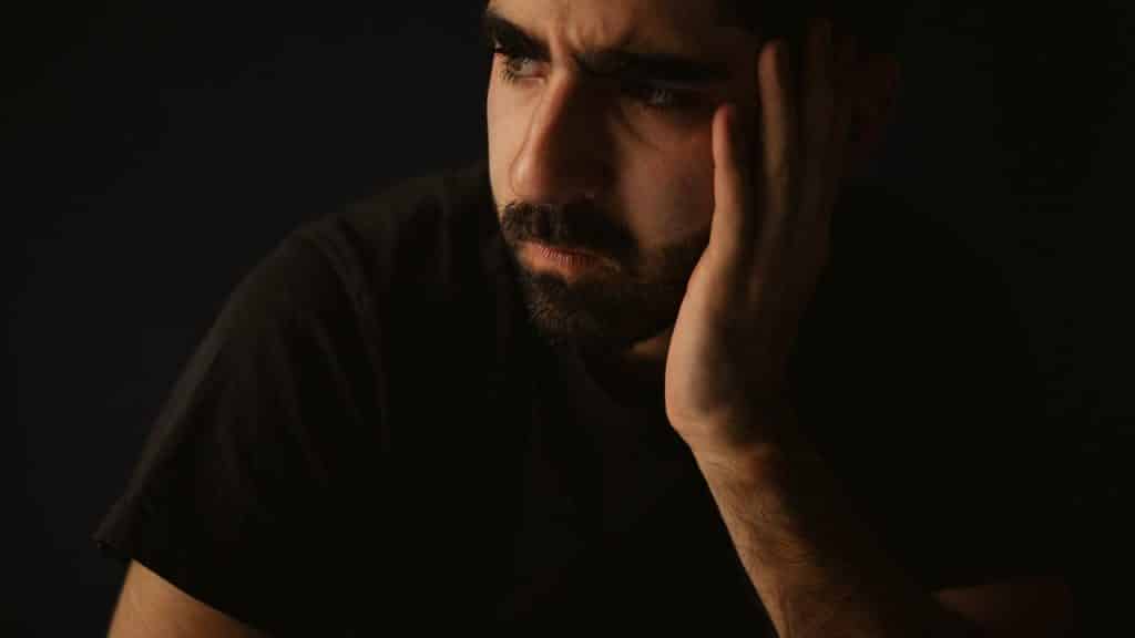 A man holding his head thoughtfully.