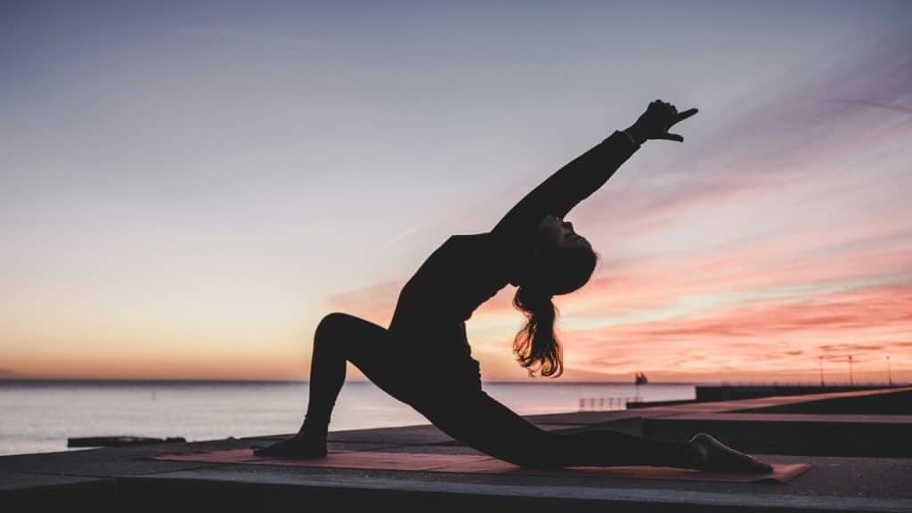 A woman doing yoga at sunset