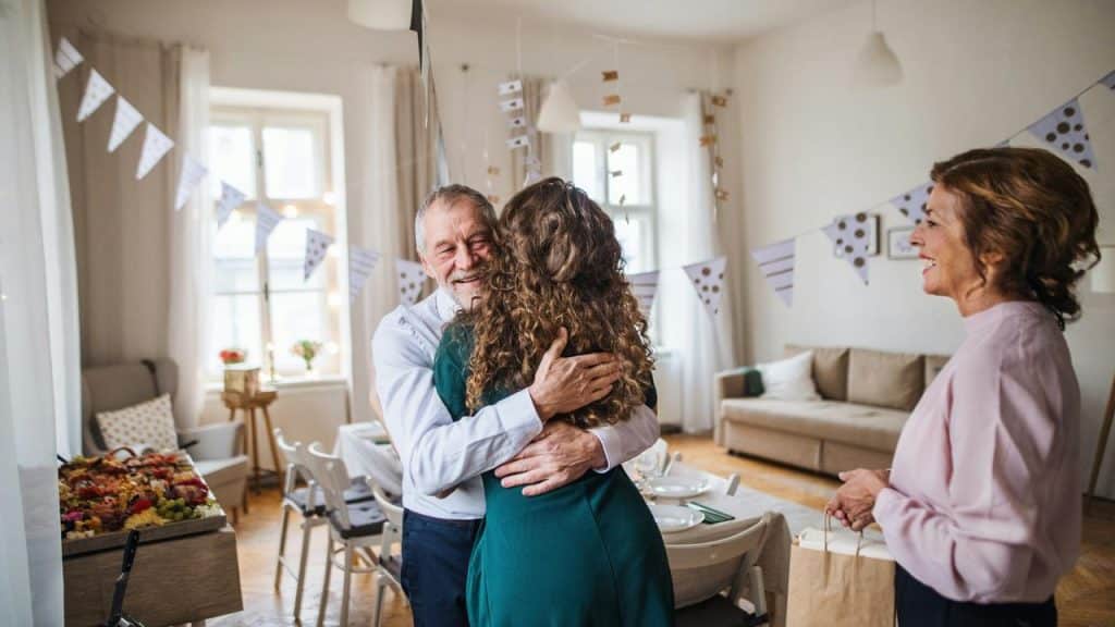 An older man hugging a young woman at a party.