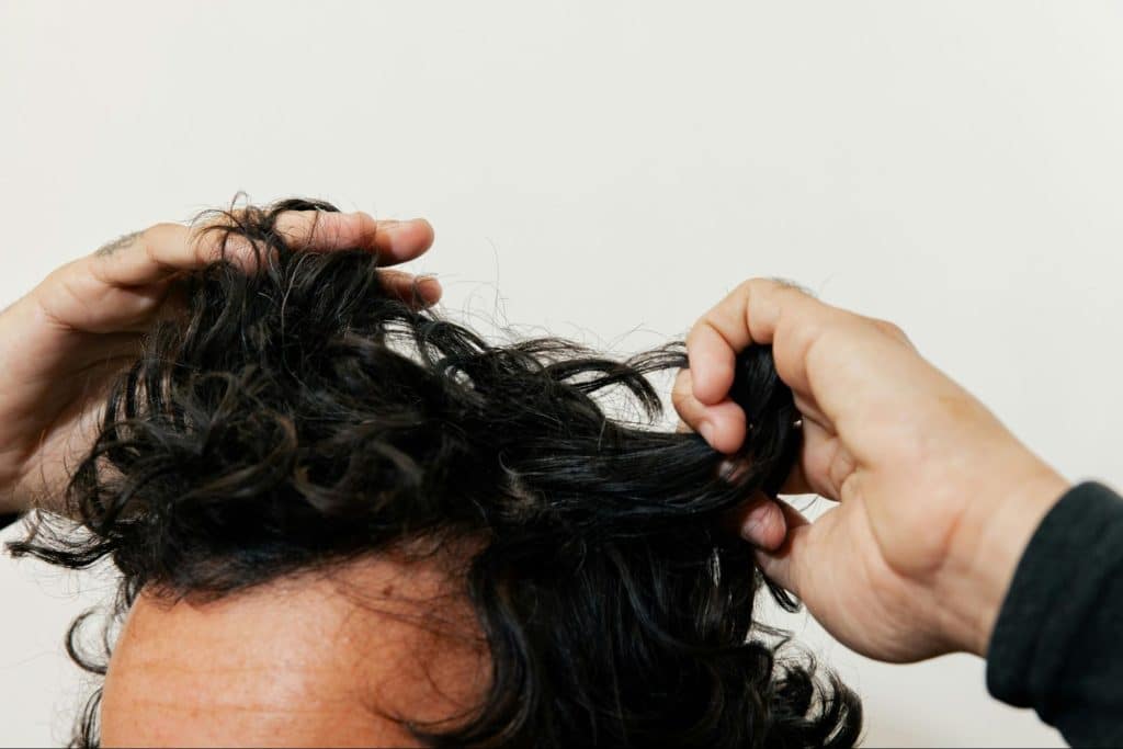 A man checking his hair for split ends