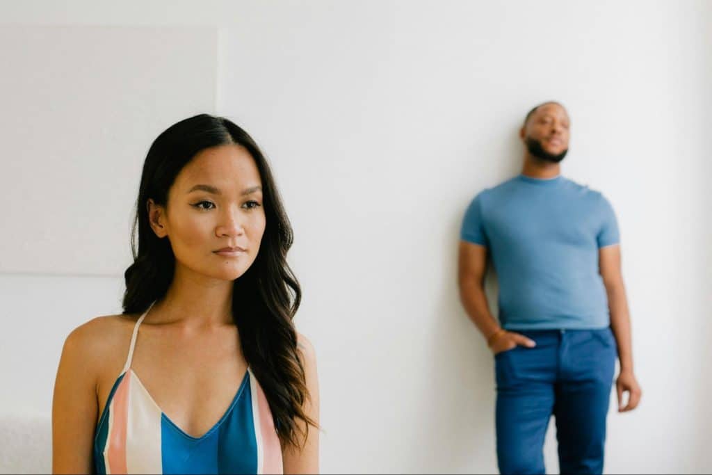 A woman standing in front of a man