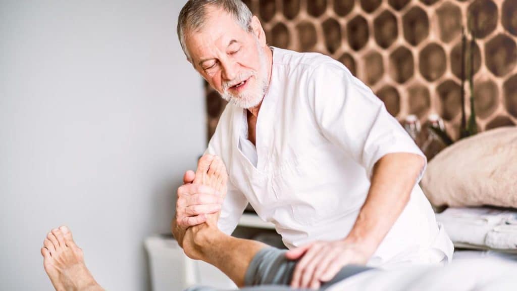 A therapist stretching a patient’s foot.