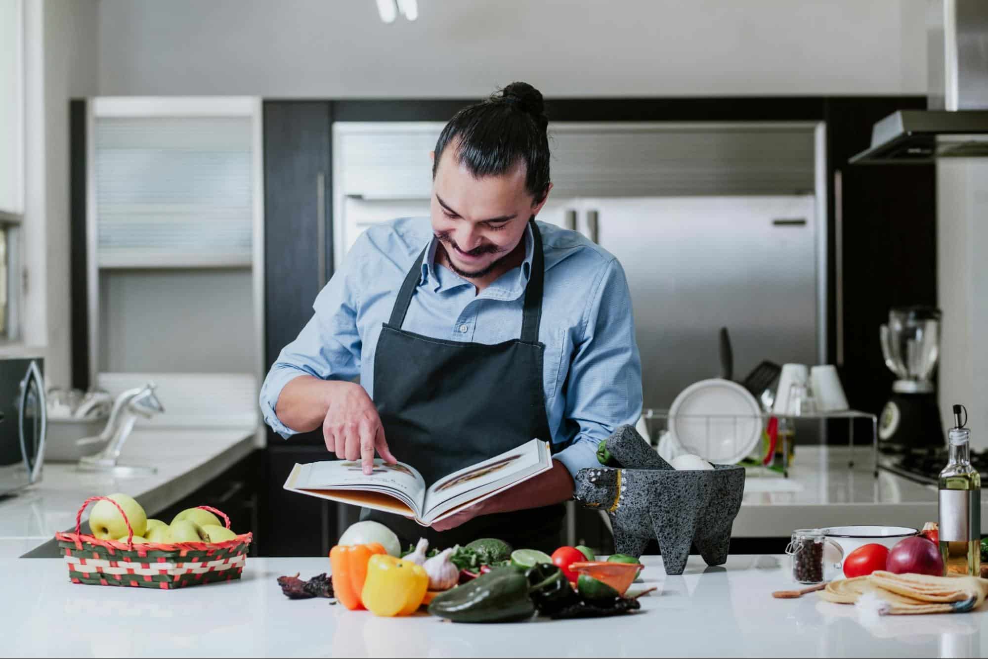 A man looking at the cookbook.
