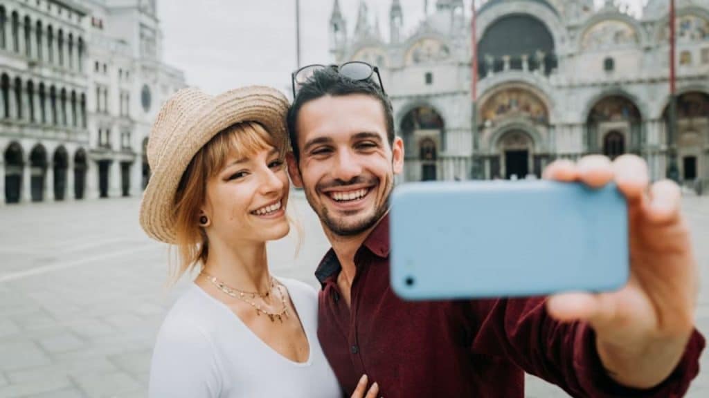 Man proudly taking a photo with his partner in a happy, public moment