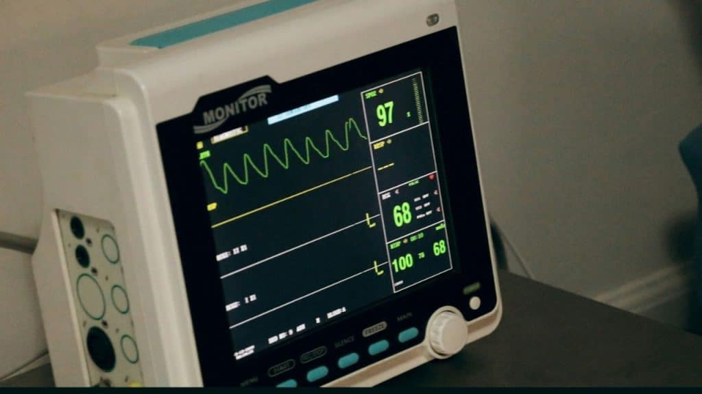 A close-up shot of a medical monitor displaying vital signs.