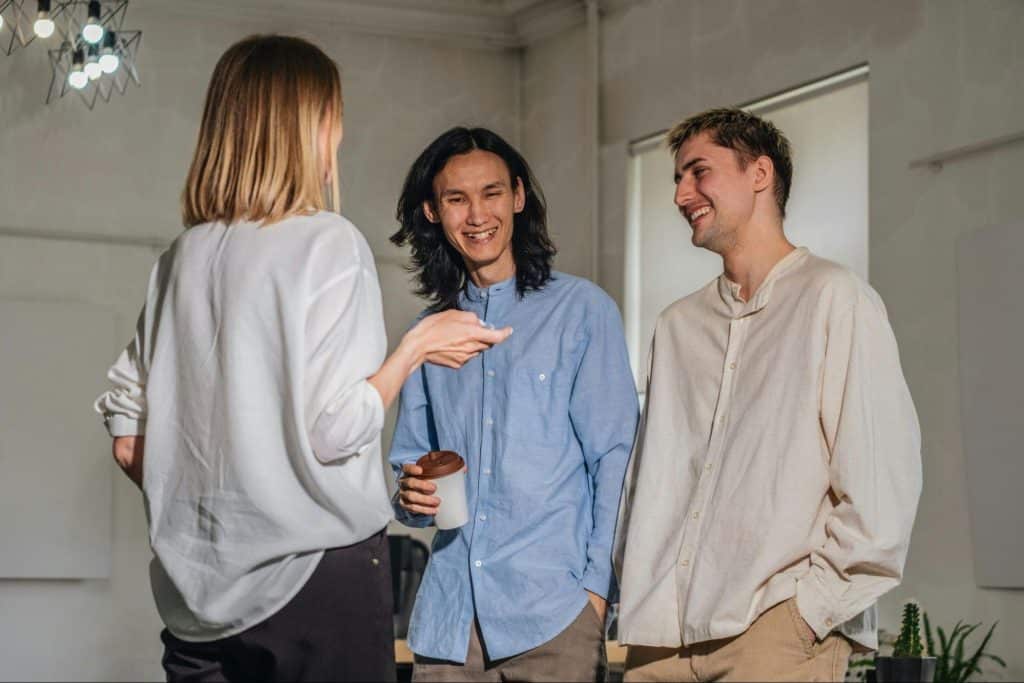 Two men talking to a woman.