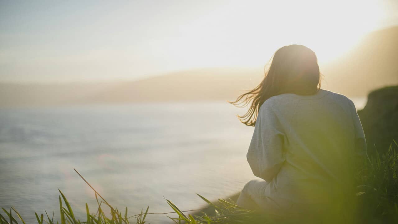 A woman watching the ocean.