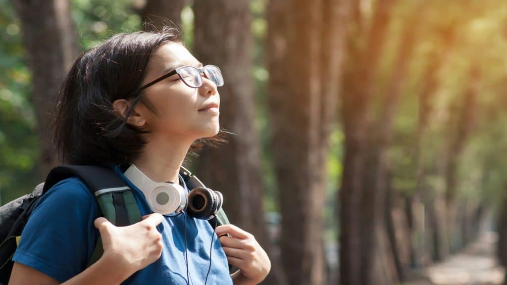 A woman having a deep breath during her hike