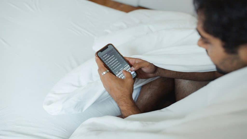 A man using his phone in bed