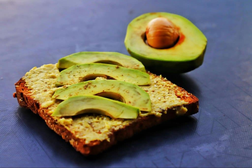 A picture of a toasted bread with an avocado on it.