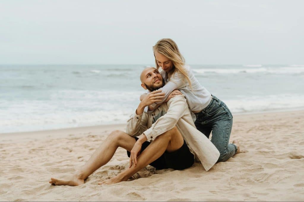 A woman hugging a man at the beach