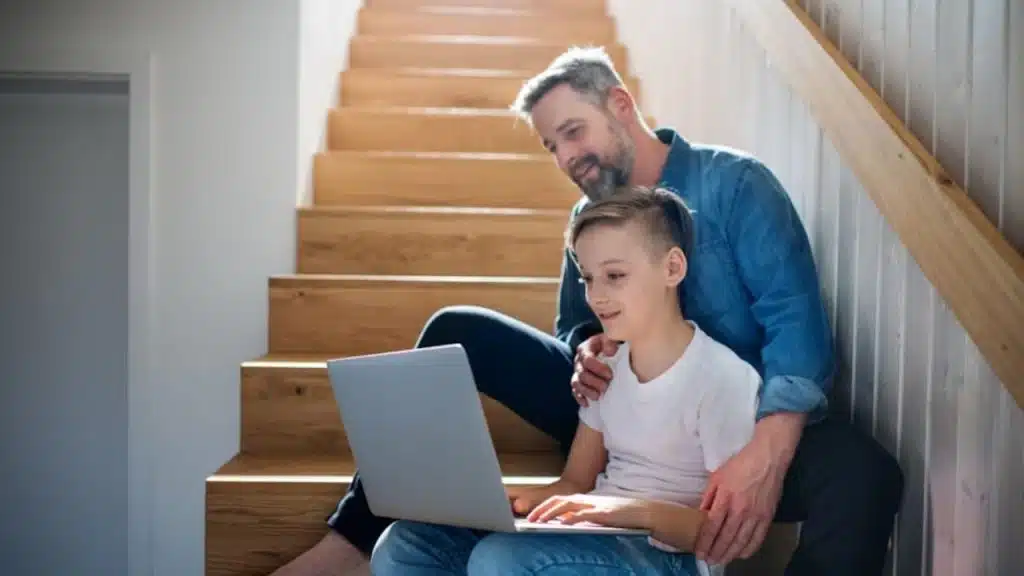 Teen working on personal project while dad looks on proudly