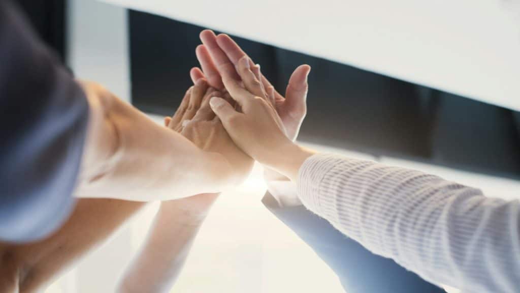 Multiple hands high-fiving.