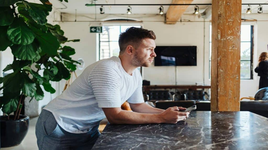A man leaning over a table while thinking