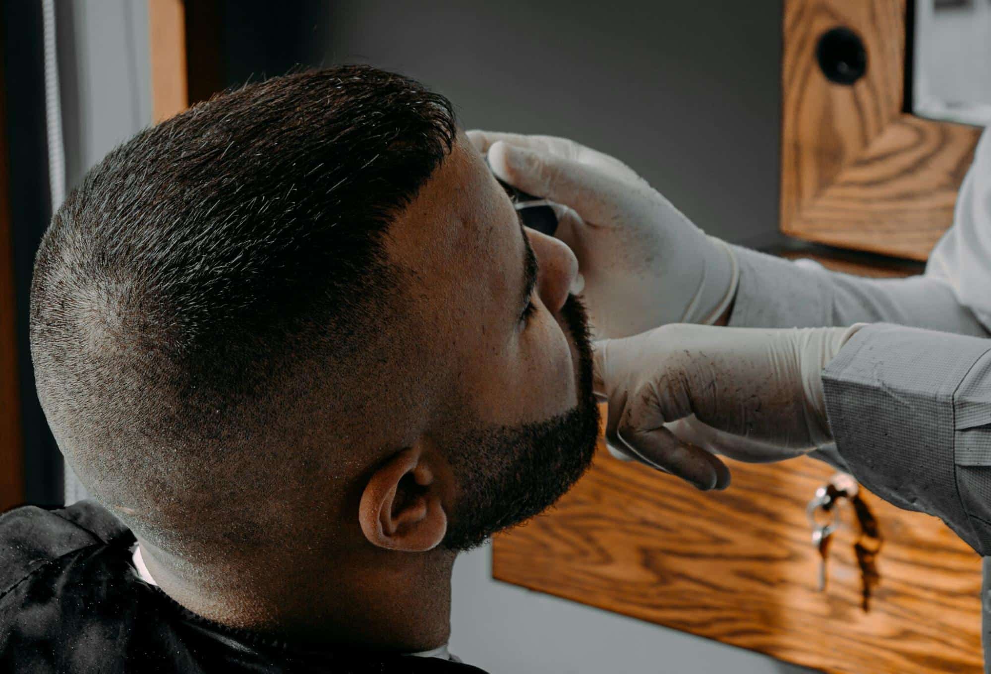 A man having his nose hair trimmed by a barber.